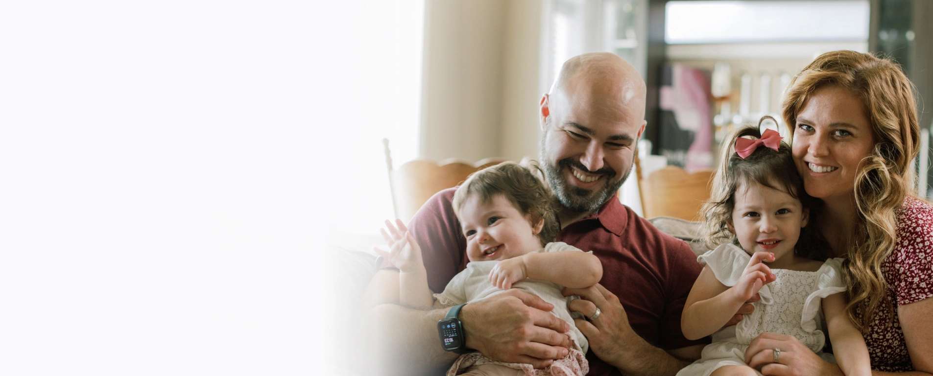 Multi-generational family embracing together indoors, showing warmth and togetherness in home setting.